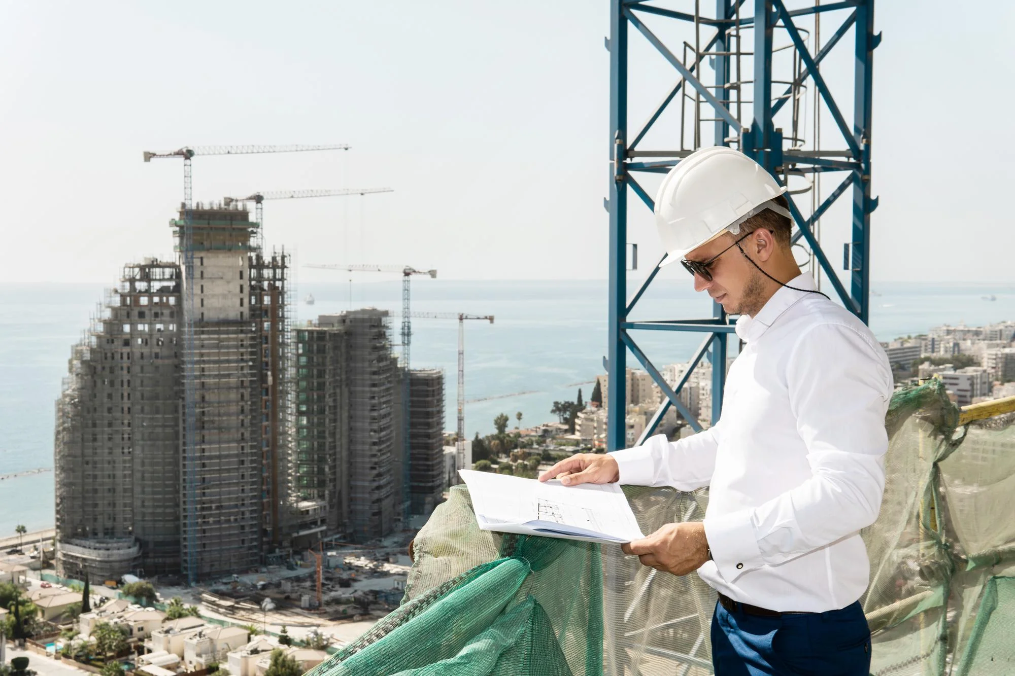 Builder reviewing project documents for RERA compliance at a high-rise construction site